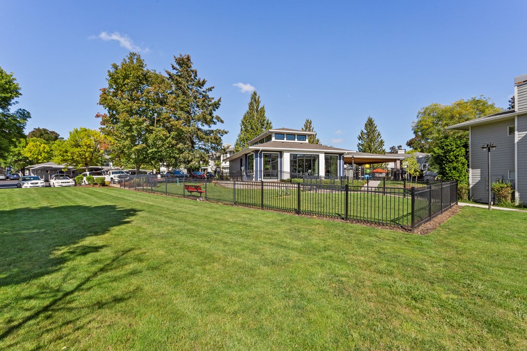 A black fence surrounds a green lawn.