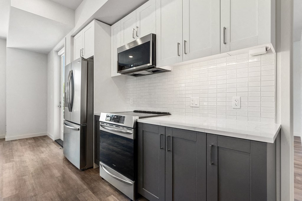 a kitchen with white cabinets and stainless steel appliances