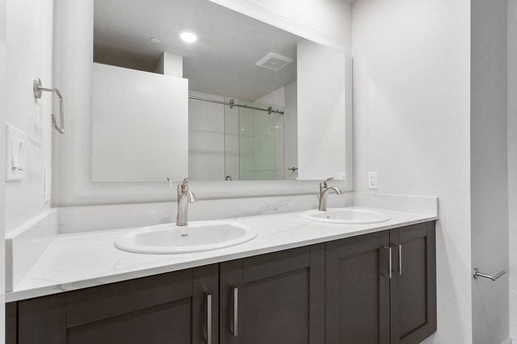 a bathroom with two sinks and a large mirror