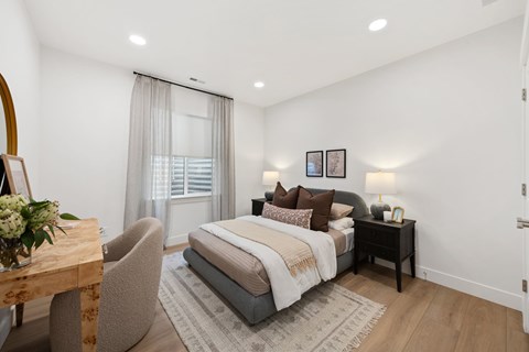 A bedroom with a bed, nightstand, and chair.