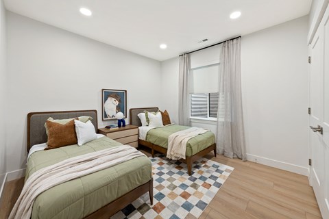 A bedroom with two beds and a window.