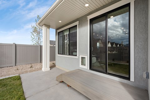 A modern house with a grey exterior and a wooden deck.