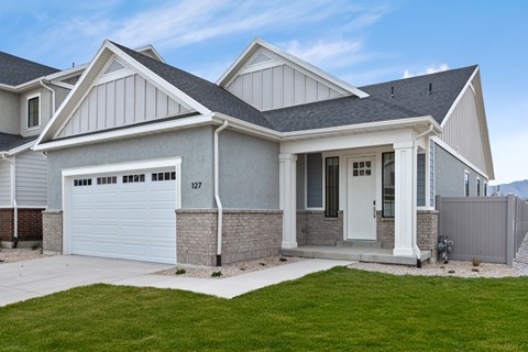 A modern house with a grey and white exterior and a garage door numbered 127.