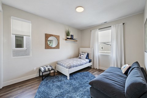 Furnished bedroom with wood plank flooring