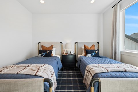 Two twin beds with blue bedspreads and white pillows in a room.