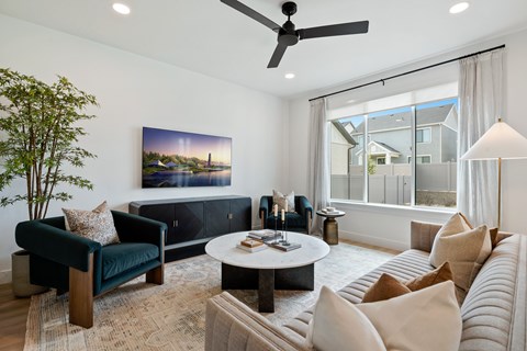 A living room with a green chair, a sofa, a coffee table, and a painting on the wall.