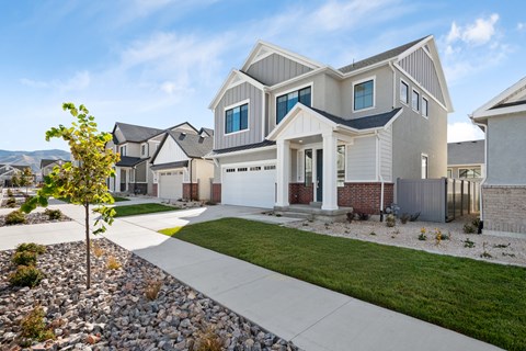 A modern house with a well-maintained lawn and a clear sky.