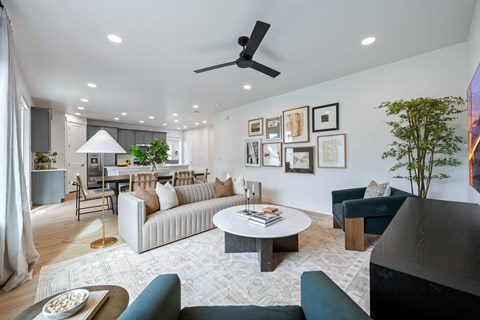 A living room with a white couch, a coffee table, and a ceiling fan.
