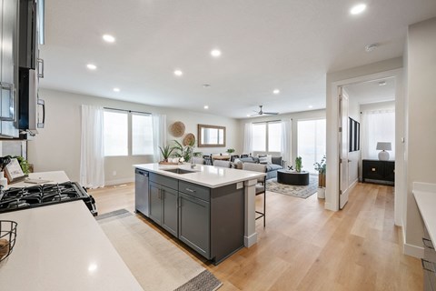A modern kitchen with a large island and a stove top oven.