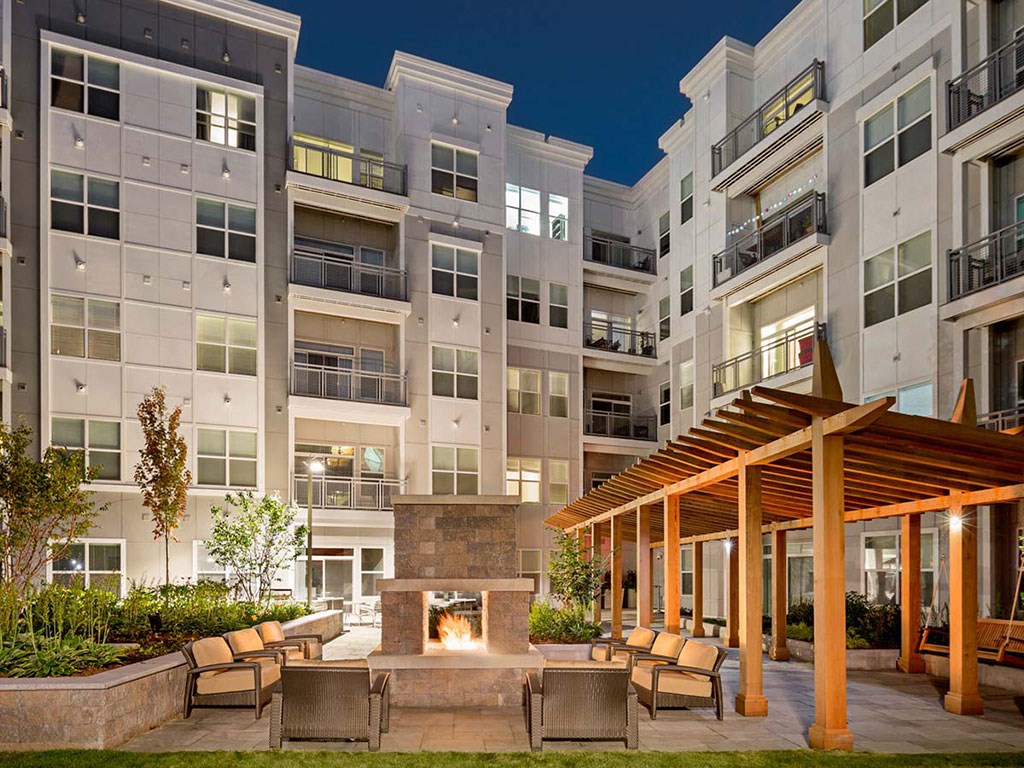 View of Atmark apartments and exterior courtyard with fireplace and patio seating