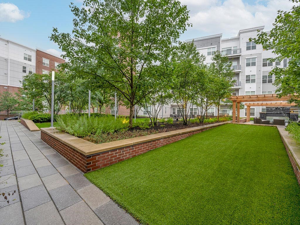 a landscaped courtyard at Atmark in Cambridge with trees and view of a patio