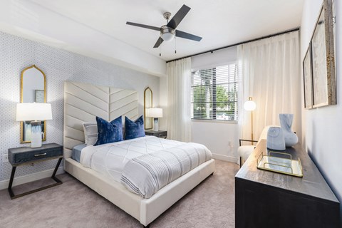A bedroom with a large bed and a ceiling fan.