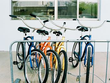 A row of bicycles are parked in a bike rack.