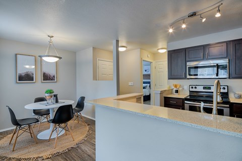 A kitchen with a table and chairs in the middle of the room.