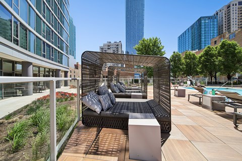 A black metal and wood outdoor seating area with a white pillow cushion.