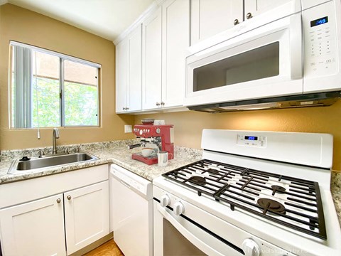 a kitchen with a stove and a sink and a microwave