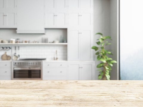 a kitchen with white cabinets and a wooden table