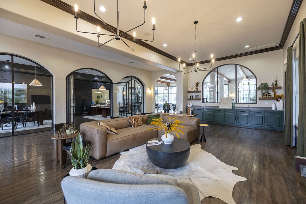 A modern living room with a large sectional sofa and a coffee table in the center.
