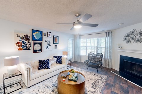 A living room with a white couch, a coffee table, a fireplace, and a ceiling fan at Inverness Cliffs, Alabama, 35242