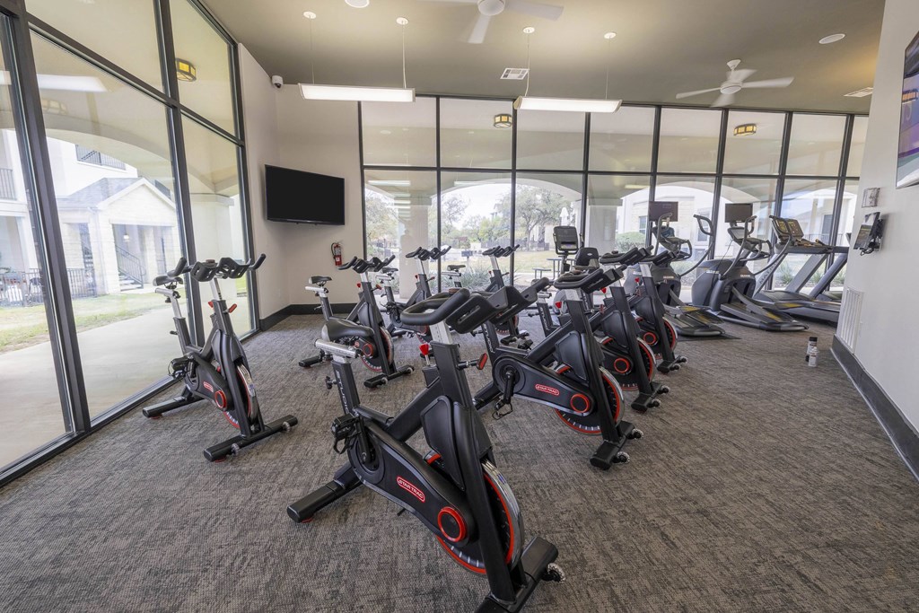 A gym with a row of stationary bikes.at Pecan Springs, San Antonio