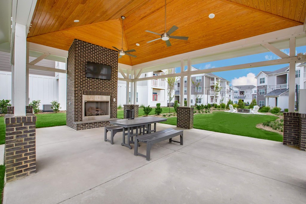 A patio with a table and chairs and a fireplace.