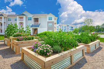 Apartment complex with a garden in front.