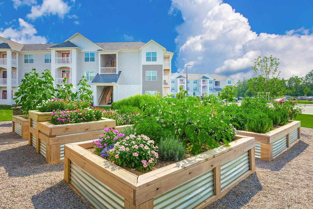 Apartment complex with a garden in front.