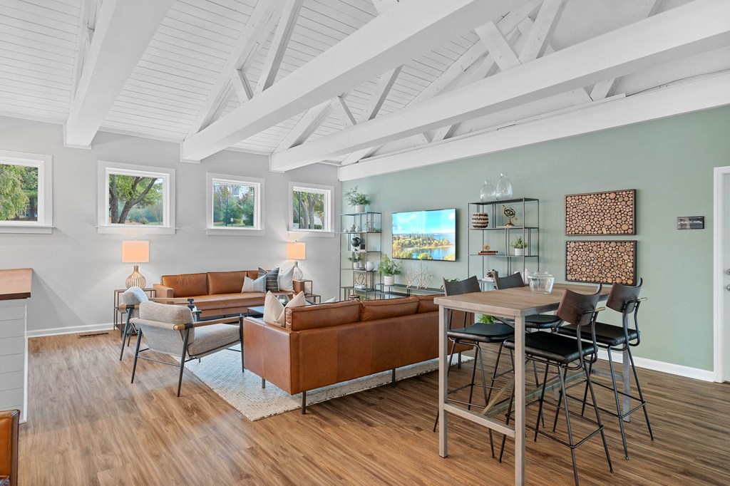 A living room with a brown couch and a dining table.