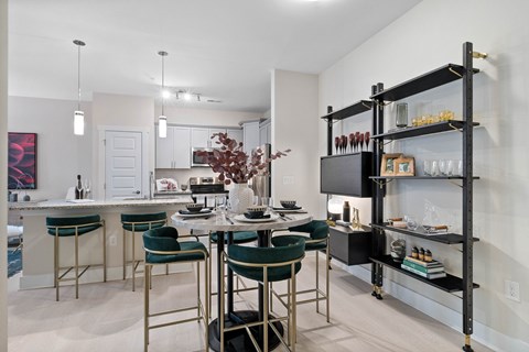 A kitchen with a table and chairs in front of a bar area.