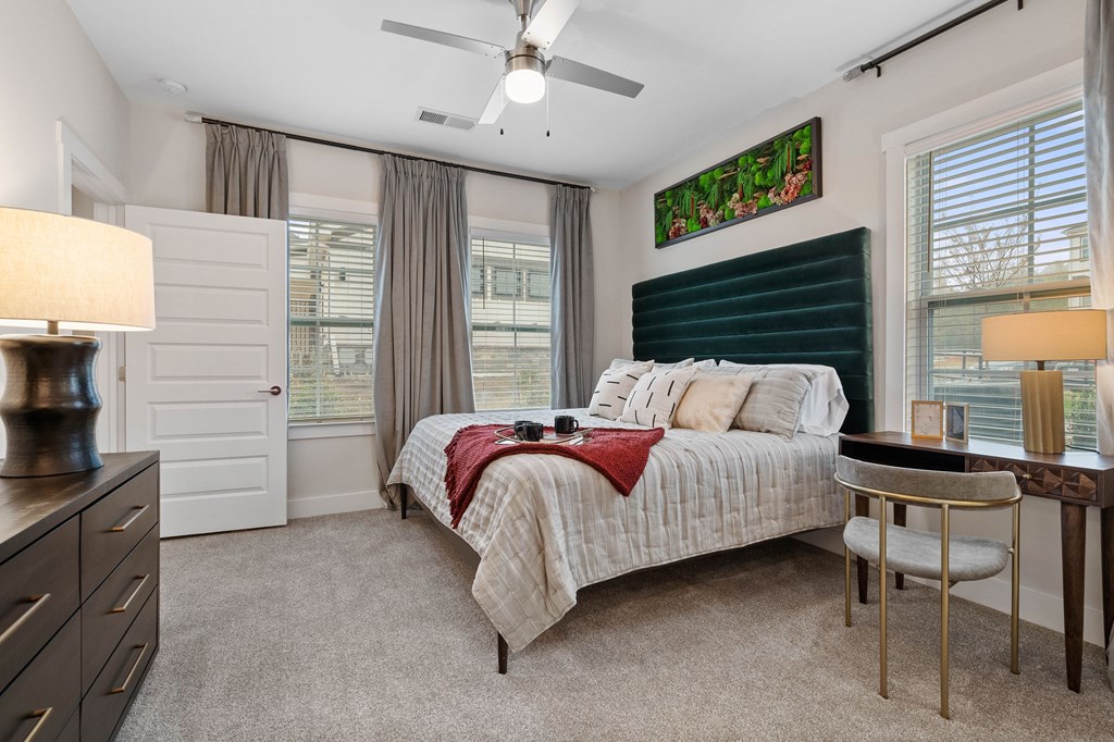 A bedroom with a bed, a desk, and a chair.