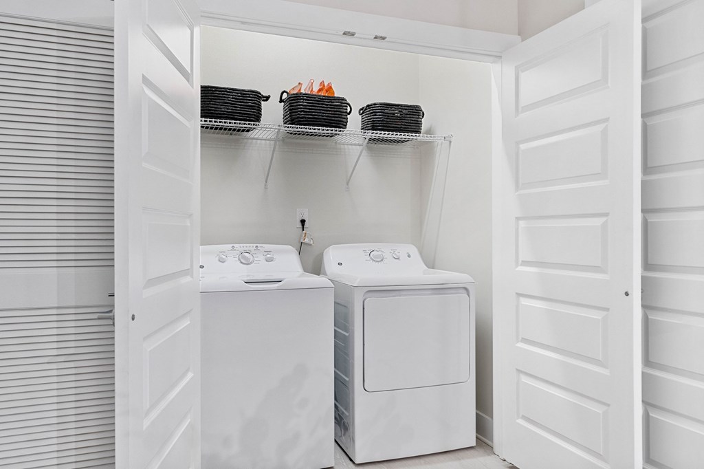 A white laundry room with a washer and dryer.