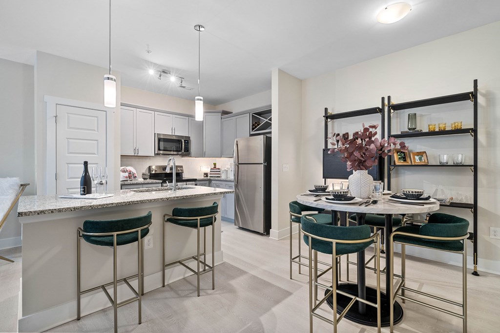 A kitchen with a table and chairs in the middle of it.