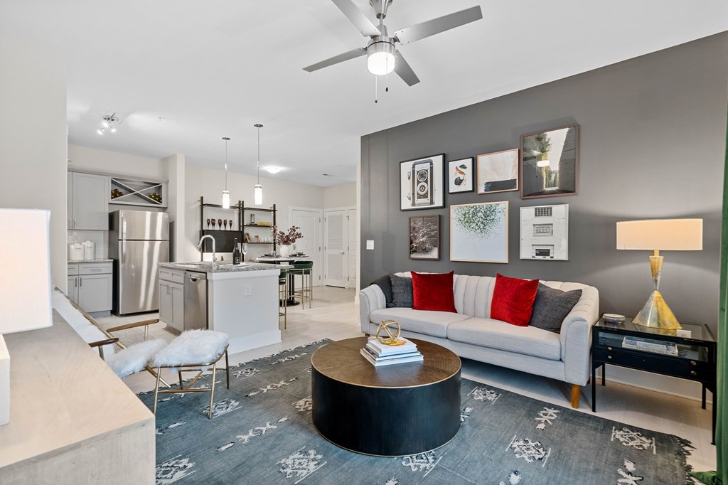 A modern living room with a grey carpet and a white sofa.