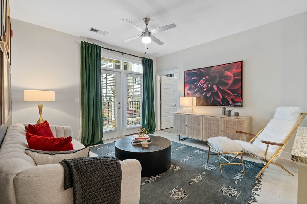 A living room with a white sofa, a round coffee table, and a painting on the wall.