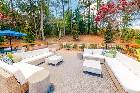 a patio with couches and tables and a deck with trees at Inverness Cliffs, Birmingham, AL, 35242