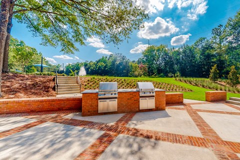 a patio with a barbecue grill and a view of a garden at Inverness Cliffs, Birmingham
