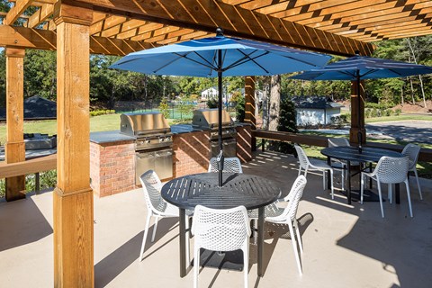 a patio with tables and chairs and umbrellas at Inverness Cliffs, Birmingham, AL