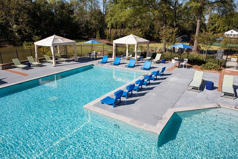 a swimming pool with blue lounge chairs and umbrellas at Inverness Cliffs, Birmingham
