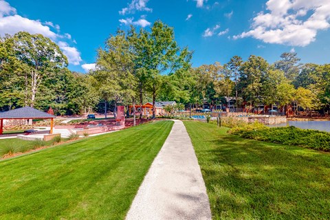a path leading to a park with a playground and a lake at Inverness Cliffs, Birmingham, 35242