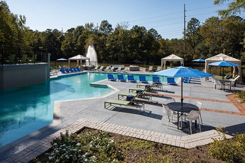 a swimming pool with lounge chairs and umbrellas at Inverness Cliffs, Birmingham, 35242
