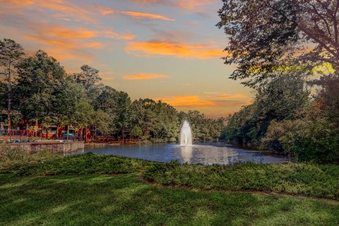 a fountain in the middle of a pond at sunset at Inverness Cliffs, Birmingham, Alabama