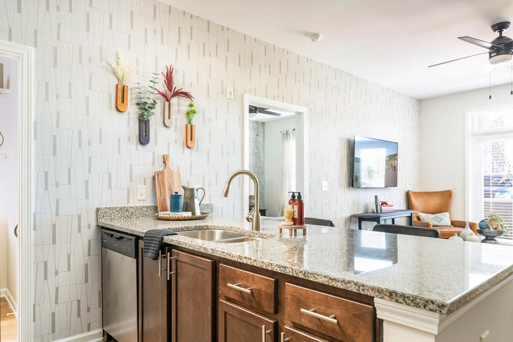 A kitchen with a white tile backsplash and wooden cabinets.