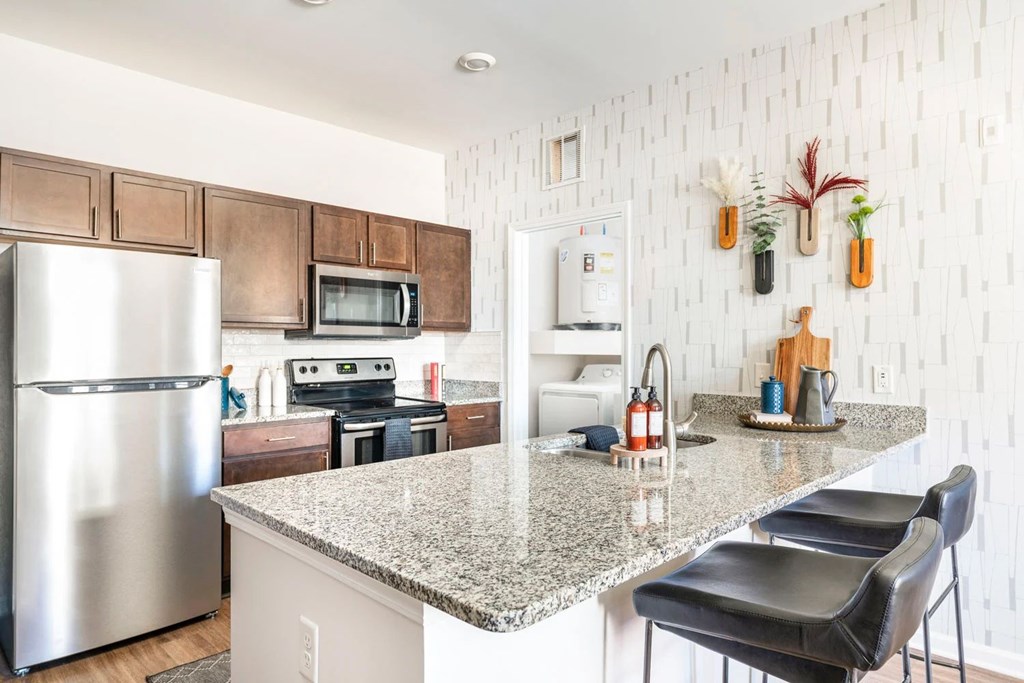 A kitchen with a granite countertop and a refrigerator.