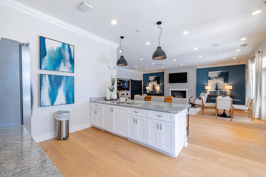 A kitchen with white cabinets and a marble countertop.