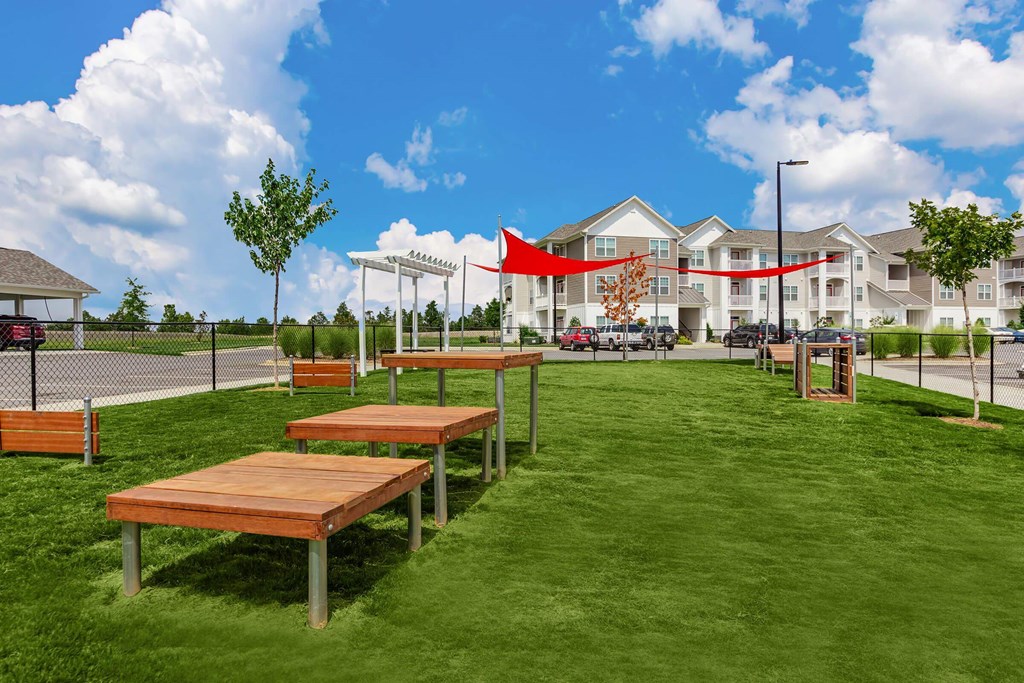 A park with benches and a building in the background.