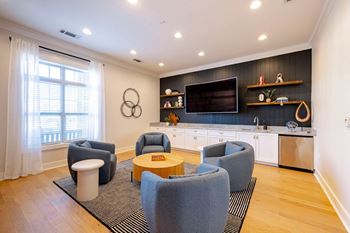 a living room with chairs and a table and a television at Concord Ridge Apartments, North Carolina