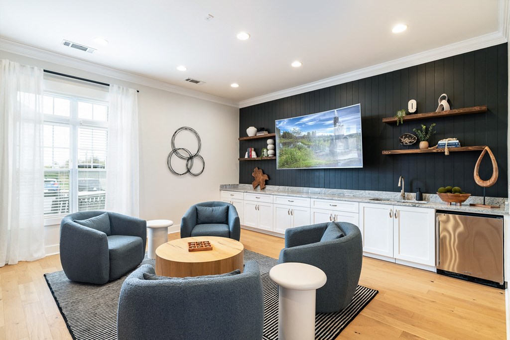 A modern living room with grey armchairs and a wooden coffee table. at Concord Ridge Apartments, North Carolina, 28027