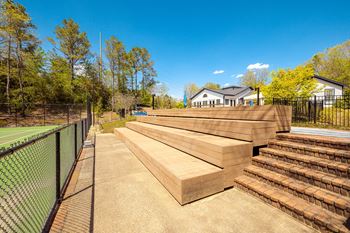 the decks are stacked up next to a tennis court and a fence at Inverness Cliffs, Birmingham, 35242