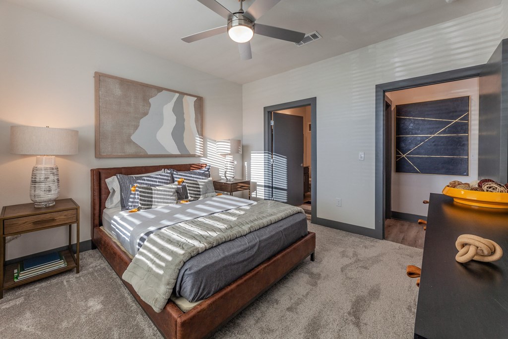 A bedroom with a large bed and a ceiling fan. A bedroom with a large bed and a ceiling fan. at Magnolia Grove Apartments, Terrell, TX