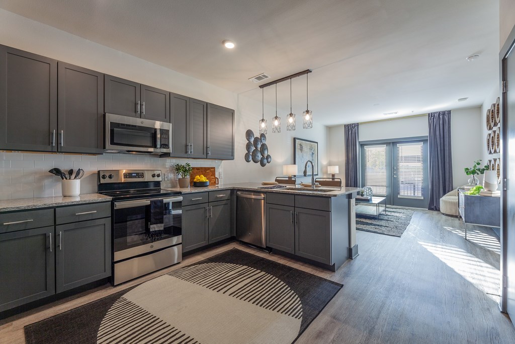 A modern kitchen with dark grey cabinets and a large island. A modern kitchen with dark grey cabinets and a large island. at Magnolia Grove Apartments, Terrell, 75160
